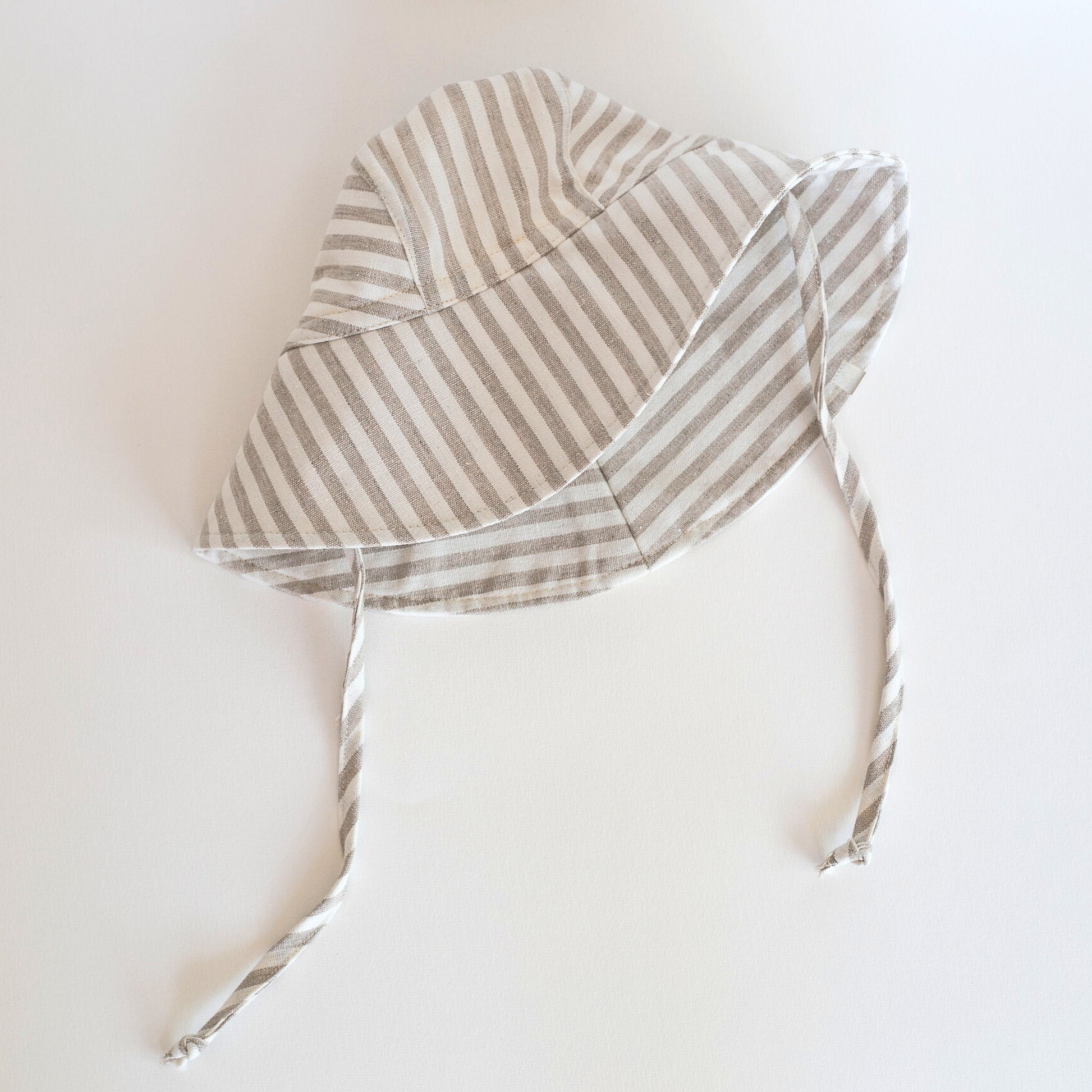 Front view of Cloudy Stripes grey stripe baby sun hat, showcasing the wide brim and stylish striped design made from breathable cotton
