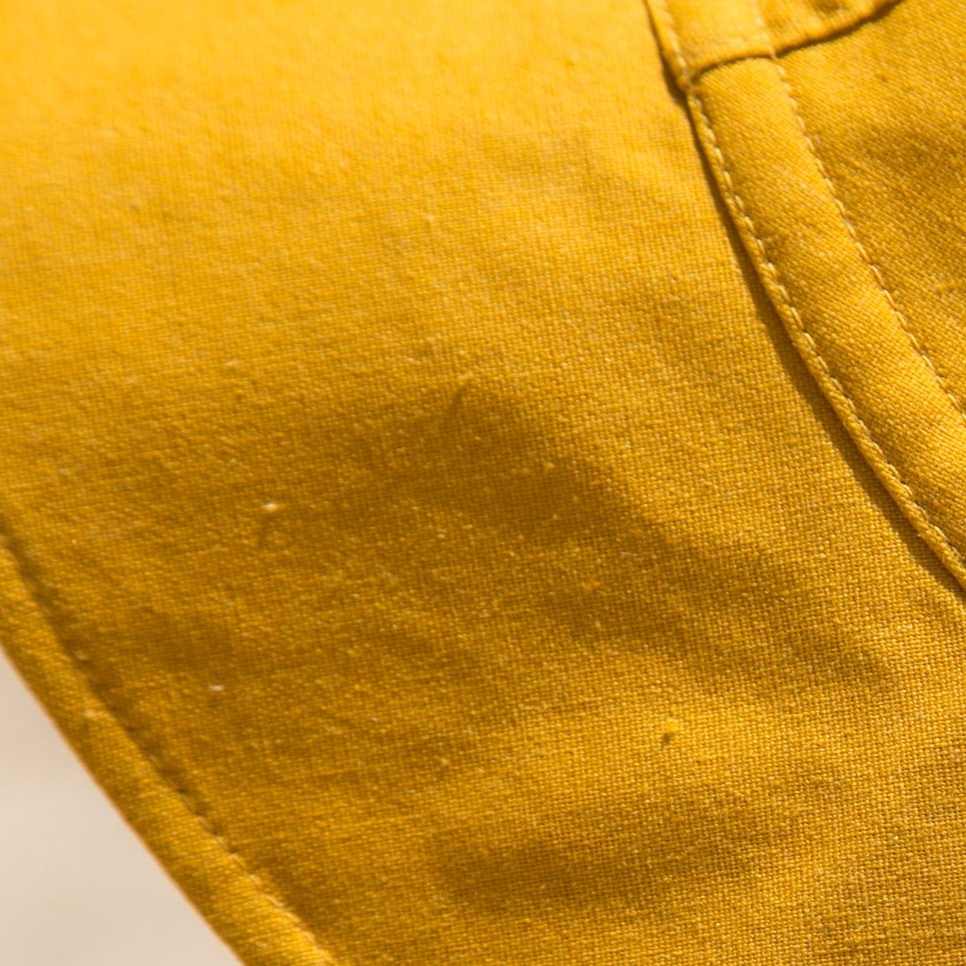 Close-up detail shot of Golden Glow mustard baby sun hat, focusing on the breathable cotton fabric, stitching, and high-quality craftsmanship