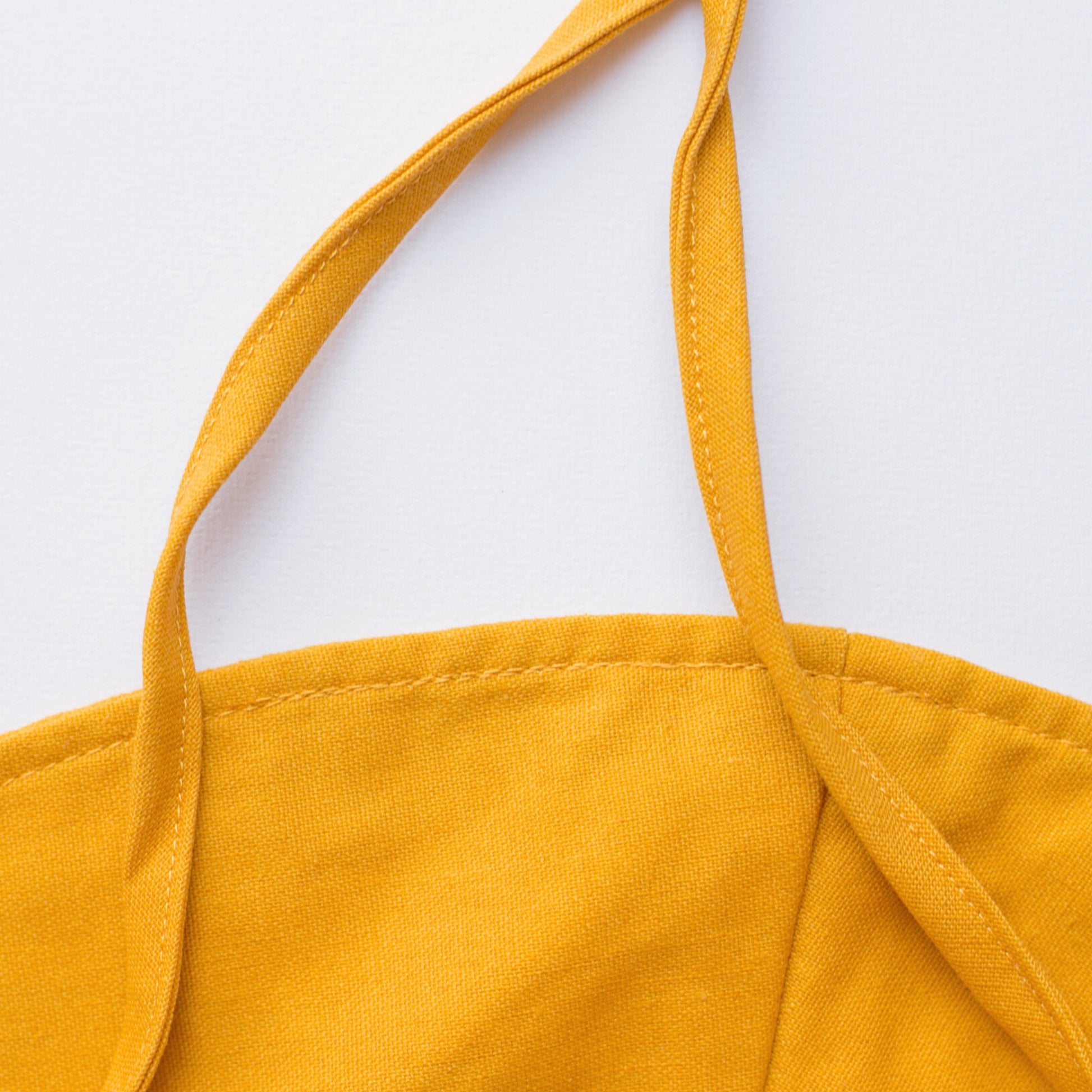 Close-up detail shot of Golden Glow mustard baby sun hat, focusing on the breathable cotton fabric, stitching, and high-quality craftsmanship