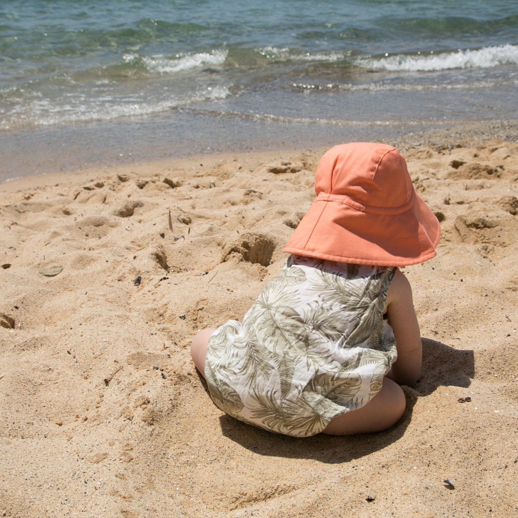 Back view of Peaches and Cream peach baby hat with adjustable neck tie and breathable cotton fabric for comfort