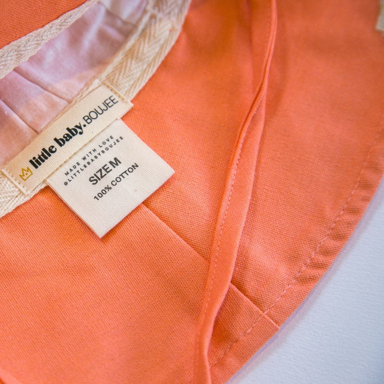 Inside view of Peaches and Cream Peach baby sun hat, showcasing the soft inner lining, breathable cotton fabric, and cotton print branding labels for a premium touch