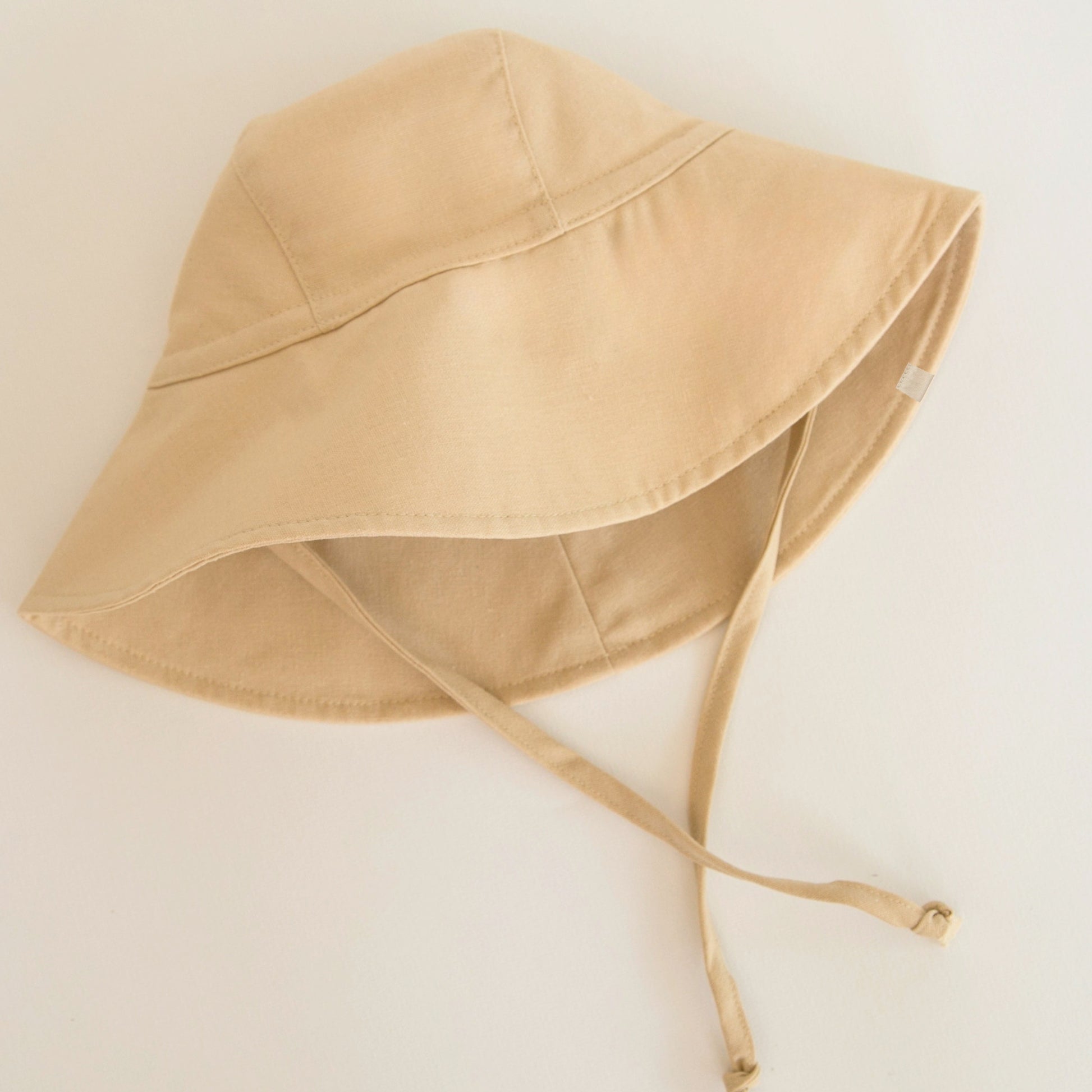 Sand Dune beige baby sun hat made from breathable cotton, designed with a wide brim for a stylish look