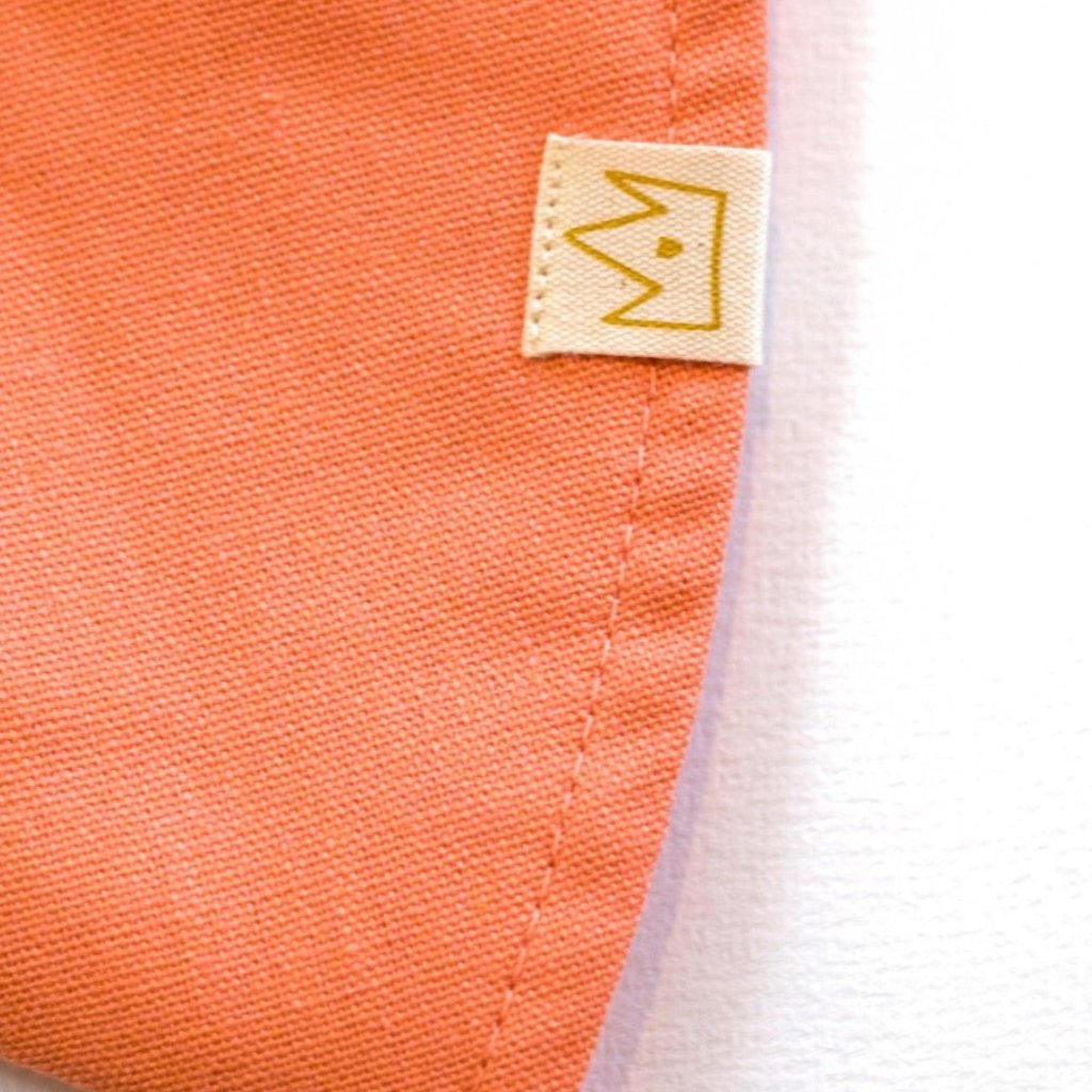 Close-up of Peaches and Cream peach baby sun hat showing breathable cotton and exterior brand tag  
